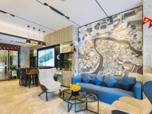 un soggiorno con un divano blu e una TV di Echarm Hotel Kunming High-speed Railway South Station Chunrong Street Metro Station a Kunming