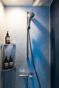 a shower in a bathroom with a blue wall at Amp Flat 清川 in Sumiyoshi +40 photos