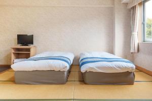 two twin beds in a room with a tv at Hotel KOYO Bekkan - Vacation STAY 37061v in Hashima