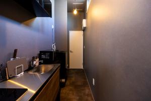 a kitchen with a sink and a white door at Amp Flat 清川 in Sumiyoshi