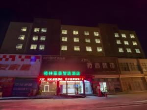 a large building with green lights in front of it at GreenTree Inn Express Shandong Zaozhuang Shizhong District Huashan Road Ginza in Zaozhuang
