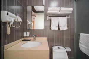 Un baño con lavabo, inodoro y espejo. en Thank Inn Hotel Jiangsu Wuxi High-Tech Zone Ruigang Pedestrian Street, en Daqiangmen 59 fotos más