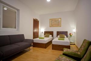 a living room with two beds and a couch at Marco Polo Party Hostel in St. Julianʼs