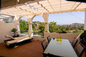 ベナアビスにあるappartement gelegen aan de golfbaan op La Quinta Benahavis Marbellaのパティオ(テーブル、椅子付)