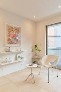 a white room with a chair and a table at Mint House Ebisu - 3 Story, Artsy & Modern Home in Shibuya in Tokyo