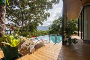 a wooden deck with a chair and a swimming pool at Escape Villa 2-Bedroom Luxury Retreat with Private Pool & Sea View in Mae Haad