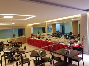 um restaurante com mesas e cadeiras e um buffet em Oft Place Hotel em Goiânia