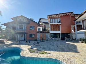 a house with a swimming pool next to a building at Cabañas Las Camelias in Cuetzalán del Progreso
