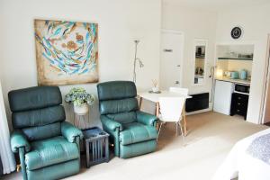 a living room with two chairs and a table at Pacific Paradise Apartment in Tutukaka