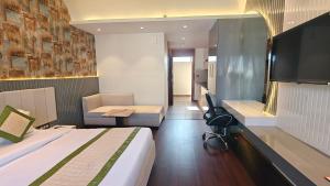 a hotel room with a bed and a desk and a chair at Hotel Livbox in Dehradun