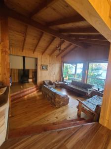 een grote woonkamer met een bank en een tafel bij Cabaña Yoka - Orilla de Lago in Pucura