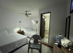 a bedroom with a bed and a chair and a mirror at Marqués 100 Exmarquesado in Oaxaca City