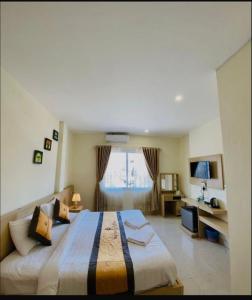 una camera da letto con un letto grande e una finestra di Downtown VangVieng Hotel a Vang Vieng