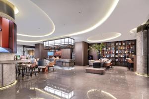 a lobby of a hotel with tables and chairs at Fromk Huankai Hotel Guangzhou Zhengjia Square Tiyuxi Road Metro stop Branch in Guangzhou