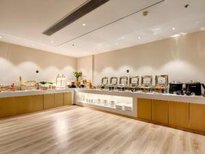 a large room with a counter with many dishes at City Comfort Inn Tangshan Railway Station Lunan District Government in Tangshan