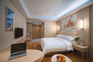 una camera d'albergo con un letto e un computer portatile su un tavolo di Vienna Hotel Zhejiang Tongxiang Puyuan a Puyuan