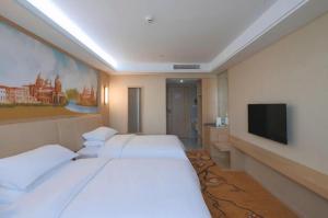Vienna Hotel Zhejiang Tongxiang Puyuan في Puyuan: غرفة فندق بها سريران وتلفزيون بشاشة مسطحة +42 صورة