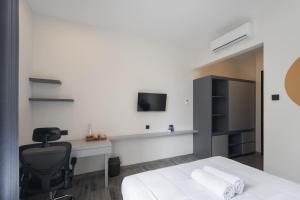 ein Schlafzimmer mit Bett, Schreibtisch und Fernseher in der Unterkunft Cove Legacy in Jakarta