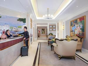 a man and a woman standing at a bar in a hotel lobby at Vienna Hotel Chengdu Exhibition Center In Time City in Chengdu