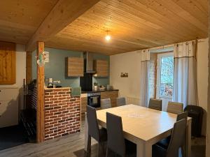 eine Küche und ein Esszimmer mit Tisch und Stühlen in der Unterkunft Appartement 6/8 personnes in Petite Chaux + 16 Fotos