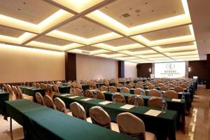 ein Konferenzraum mit grünen Tischen und Stühlen und einer Leinwand in der Unterkunft Vienna Hotel Hunan Changsha Gaoling in Changsha