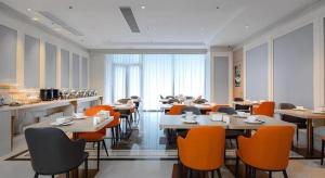un ristorante con tavoli e sedie in una stanza di Vienna Hotel Hangzhou East Railway Station West Square a Hangzhou