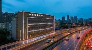 ein großes Gebäude auf einer Autobahn mit Autos darauf in der Unterkunft VX Hotel Wuhan Optics Valley Yangjia Bay Metro Station in Wuhan