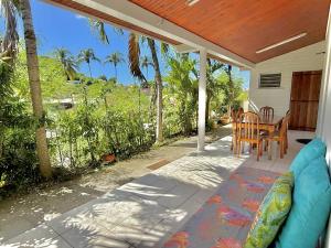 porche con sofá azul, mesa y sillas en Appt T3 - Bourg de Sainte Anne, en Sainte-Anne