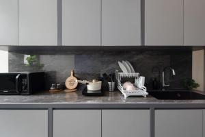 eine Küchentheke mit Spüle und Mikrowelle in der Unterkunft Cove Legacy in Jakarta + 9 Fotos