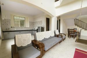 un soggiorno con due sedie e una cucina di Hemgiri - 6BHK Pool Garden Luxury Villa Girivan Mulshi near Pune Mumbai a Kolvan