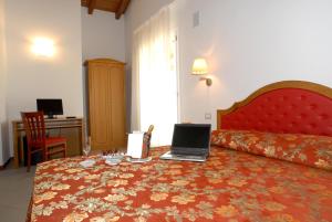 Habitación de hotel con cama con ordenador portátil en Villa Aretusi en Bolonia