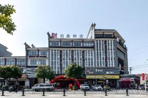 ein großes Gebäude, vor dem Autos parken in der Unterkunft Borrman Hotel Jiangyin Zhouzhuang in Xiwujieqiao