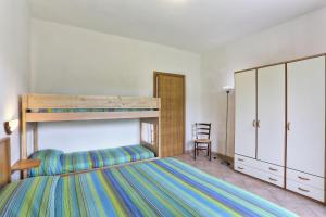 1 dormitorio con litera y silla en Famiglia Ricci, en Marina di Campo