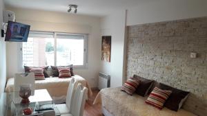 ein Wohnzimmer mit 2 Betten und einer Ziegelwand in der Unterkunft Caronti Suites in Bahía Blanca