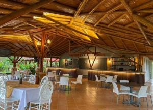 a restaurant with tables and white chairs and wooden ceilings at Yopo Resort in Yopal