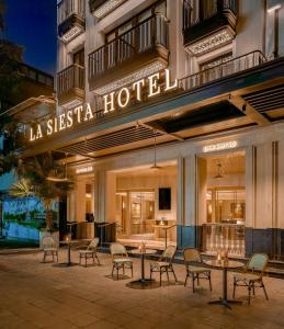 a hotel with tables and chairs in front of a hotel at La Siesta Premium Lakeside in Hanoi