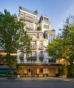 ein großes weißes Gebäude mit einem Schild darauf in der Unterkunft La Siesta Premium Lakeside in Hanoi