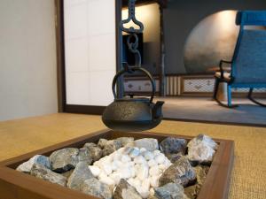 una stanza con un vassoio di pietre e un bollitore per il tè di SORAIRO Miyajima a Hatsukaichi