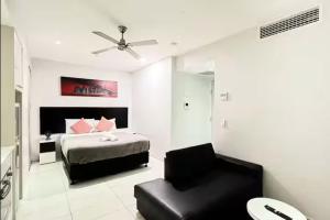 Cozy Studio in the heart of CBD C4 في بريزبين: غرفة نوم بها سرير وكرسي +7 صور