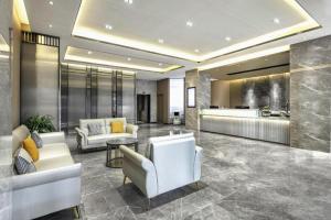 eine Lobby mit zwei weißen Stühlen und einem Tisch in der Unterkunft GYA Hotel Taiyuan Zonggai Zone Ancient County Chengnan Station in Taiyuan