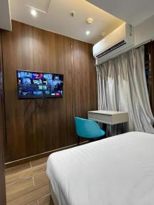 a hotel room with a bed and a tv on a wall at Sunny Day Hotel in Hong Kong