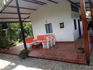 Un patio de una casa con muebles rojos y blancos. en El Molino - Your perfect getaway awaits you here!, en Pamplonita