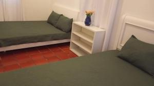 Una habitación con dos camas y un jarrón de flores sobre una mesa. en El Molino - Your perfect getaway awaits you here!, en Pamplonita