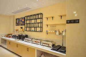 eine Küche mit einer Theke mit vielen Töpfen und Pfannen in der Unterkunft City Comfort Inn Wuhan Yuanlin Road Metro Station in Wuhan