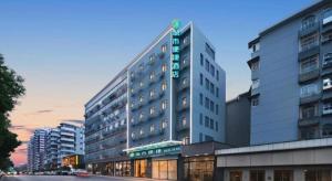 ein hohes Gebäude mit einem Schild an der Seite in der Unterkunft City Comfort Inn Wuhan Huanghe Tower Shouyi Metro Station in Wuhan