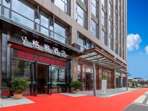 a building with a red carpet in front of it at Gya Hotel Kunming Zijin Center Xiaodongcun Metro Station in Kunming