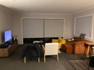 哈士汀Olive & Jarvis Homestay的客厅里有一张沙发和一台电视