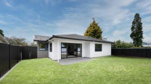 哈士汀Olive & Jarvis Homestay的一座白色的小房子,设有绿色草坪