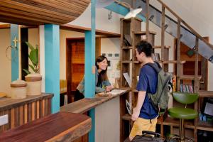 a man and a woman standing at a counter at The Pax Hostel in Osaka