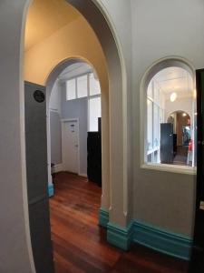 Un arco que conduce a una sala de estar con pisos de madera. en 1849 Accommodation, en Albany